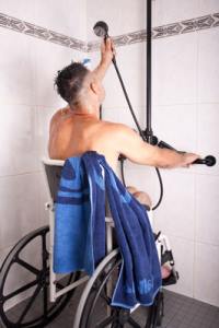 Mann mit Rollstuhl in Dusche